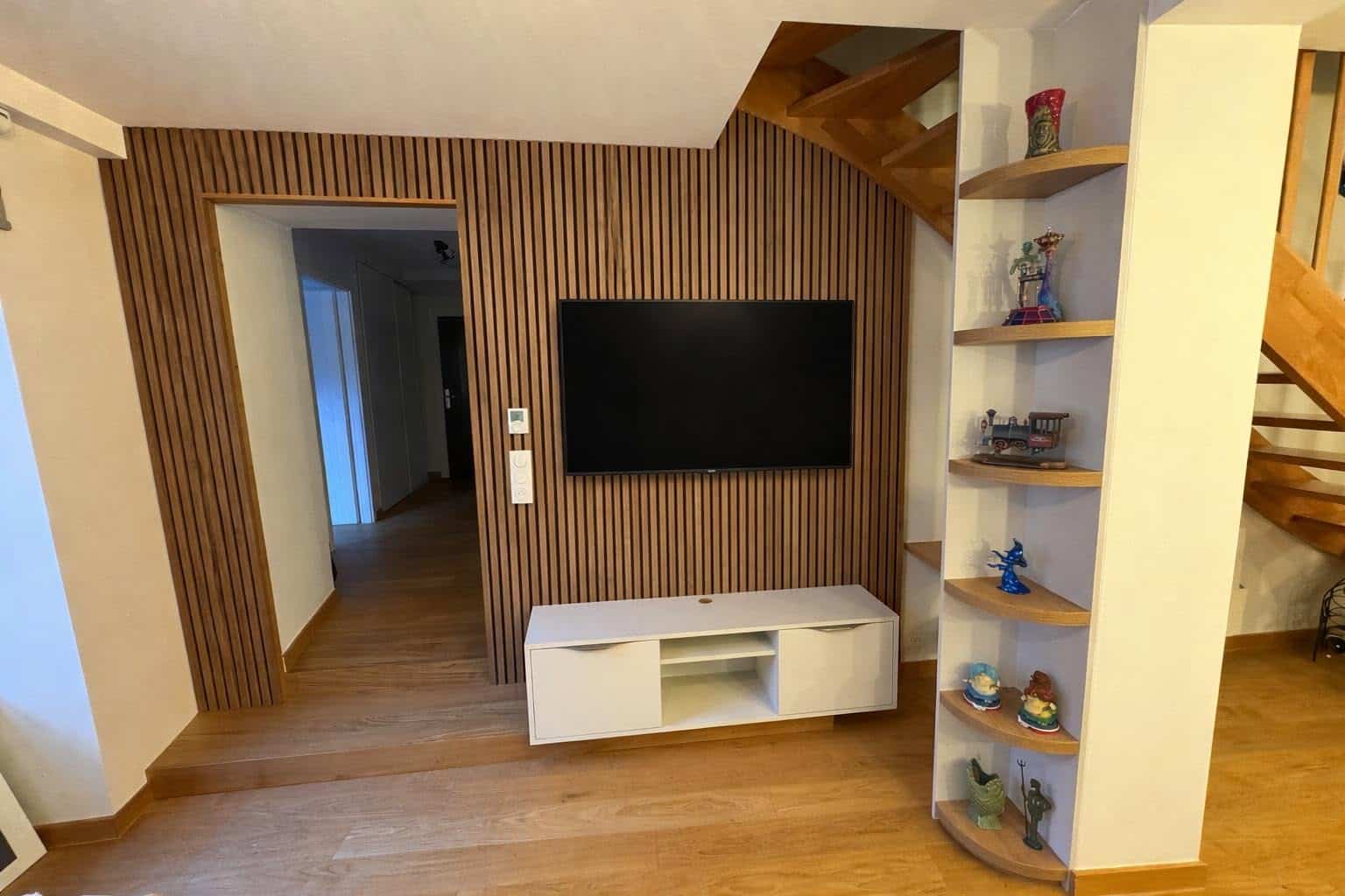 Réaménagement d'un appartement à Strasbourg : Habillage mural en tasseaux bois avec feutrine acoustique et intégration TV